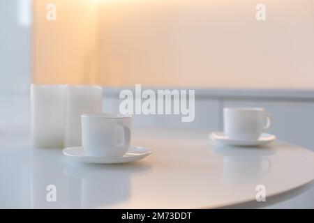 Weiße Tasse auf dem Küchentisch im Hintergrund Stockfoto