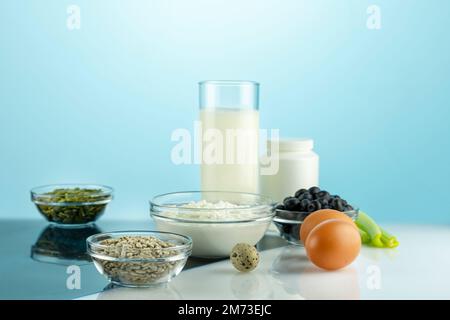 Nahrung mit Kalzium für gesunde Knochen und Gelenke. Produkte mit hohem Gehalt an Calcium, Nahrungsergänzungsmitteln und Röntgenfilm auf dem weißen Tisch. Gesunde Ernährung. Essen für gesunde b Stockfoto