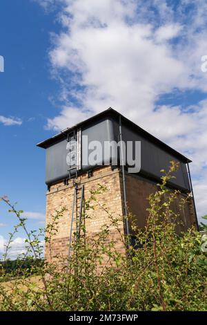 Ein Wasserturm, der Anfang des 20. Jahrhunderts erbaut wurde, um Wasser aus gepumptem Wasser für Bauernhof und Hütten in der Nähe des Dorfes Roxburgh, schottische Grenzen, bereitzustellen Stockfoto