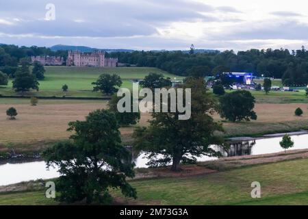 Die Bühne für Sommerkonzerte im Freien im Floors Castle, Kelso, wurde von Roxburgh Castle aus während einer Aufführung Anfang Juli, nach 10pm, mit The Rive gesehen Stockfoto