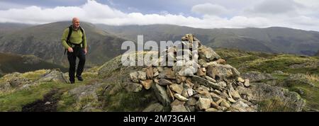 Walker am Gipfelkairn auf Gibson Knott Fell, über Thirlmere in den Central Fells, Lake District National Park, Cumbria, England, UK Gibson Knott Stockfoto