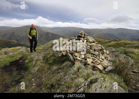 Walker am Gipfelkairn auf Gibson Knott Fell, über Thirlmere in den Central Fells, Lake District National Park, Cumbria, England, UK Gibson Knott Stockfoto