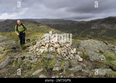 Walker am Gipfelkairn auf Gibson Knott Fell, über Thirlmere in den Central Fells, Lake District National Park, Cumbria, England, UK Gibson Knott Stockfoto