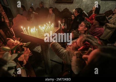 Gaza-Stadt, Palästinensische Gebiete. 07. Januar 2023. Palästinensische griechisch-orthodoxe Christen besuchen eine Weihnachtsmesse unter der Leitung des griechisch-orthodoxen Erzbischofs Alexios in St. Porphyrios Kirche. Kredit: Mohammed Talatene/dpa/Alamy Live News Stockfoto