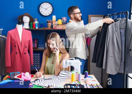 Männer und Frauen, die selbstbewusst in der Bekleidungsfabrik arbeiten Stockfoto