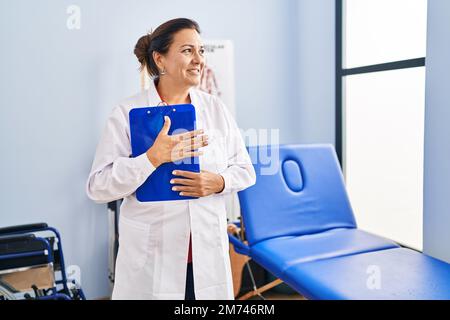 mittelalterliche hispanische Physiotherapeutin mit Clipboard in der Reha-Klinik Stockfoto