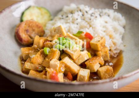 Gericht mit gebratenem Tofu, Reis und Gemüse. Stockfoto