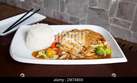 Gericht mit knuspriger Ente in einem Restaurant in Tokio. Asiatische Kombi-Platte mit Gemüse und Reis. Stockfoto