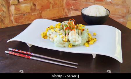 Asiatische Kombi-Platte mit Fisch, serviert mit Reis oder Nudeln. Gericht mit gekochten Königsgarnelen in einem Restaurant in Tokio. Stockfoto