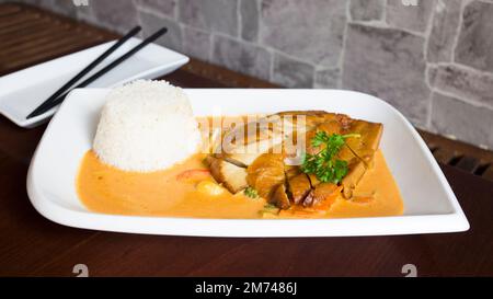 Asiatische Kombi-Platte mit Huhn in Currysauce und Gemüse serviert mit Reis. Stockfoto