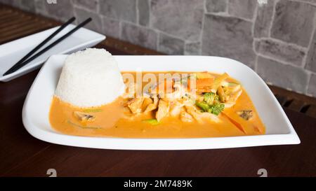 Asiatische Kombi-Platte mit Huhn in Currysauce und Gemüse serviert mit Reis. Stockfoto