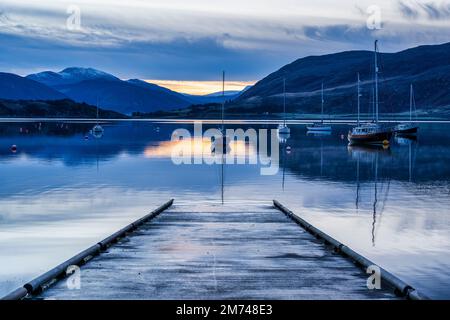 Blick von der Hellbahn der Yachten, die bei Tagesanbruch auf Loch Broom festgemacht sind - Ullapool, Wester Ross, Highland, Schottland, Großbritannien Stockfoto