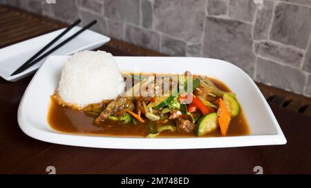 Asiatische Kombi-Platte mit Rindfleisch in Currysauce und Gemüse serviert mit Reis. Stockfoto