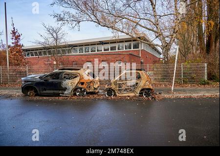 Berlin, Deutschland - 12. Dezember 2022: Wracks von zwei ausgebrannten Autos am Straßenrand. Stockfoto