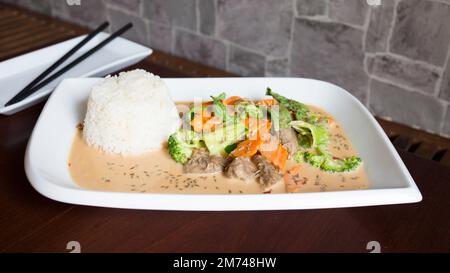 Asiatische Kombi-Platte mit Rindfleisch in Currysauce und Gemüse serviert mit Reis. Stockfoto