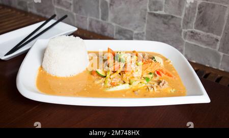 Asiatische Kombi-Platte mit Rindfleisch in Currysauce und Gemüse serviert mit Reis. Stockfoto