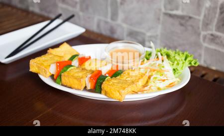 Vegetarische asiatische Kombi-Platte mit gemischtem Gemüse und gebratenem Tofu serviert mit etwas Reis. Stockfoto