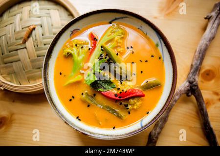 Asiatische Currysuppe mit Fleisch und Gemüse, serviert in einer Schüssel. Stockfoto