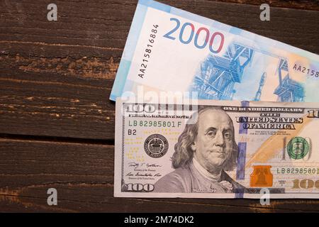 Banknoten US-Dollar und Banknoten Russische Rubel auf schwarzem Hintergrund. Tapeten für Wirtschaft und Finanzen Stockfoto