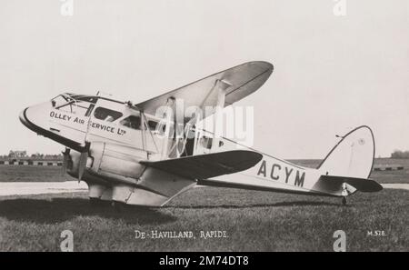 Eine klassische fotografische Postkarte mit dem Titel „De-Havilland Rapide“, auf der die Olley Air Service Ltd DH.89 Dragon Rapide „G-ACYM“ abgebildet ist. Olley Air Service wurde 1934 von Gordon Olley gegründet, einem ehemaligen Piloten bei Handley Page Transport und Imperial Airways. Dieses Flugzeug wurde im Januar 1935 bei Olley Air Service registriert, Anfang WW2 in den RAF-Dienst gepresst und bei der Evakuierung aus Frankreich im Mai 1940 durch Feuer zerstört. Stockfoto