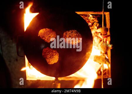 Top-down-Schuss Fleischpasteten, die in den kalten Wintern von delhi auf Kohleholz-Feuerwehr-Street-Food als Snack gekocht werden Stockfoto