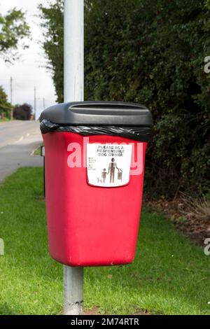 Red Dog Poo bin am Post befestigt, Church Lane Cherry Willingham Lincoln 2022 Stockfoto