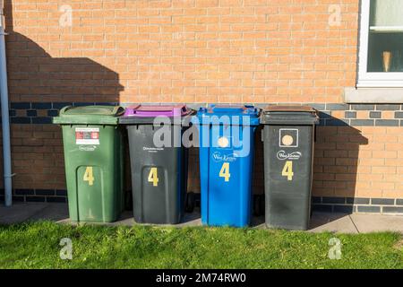 Mülltonnen stehen neben dem Haus. Stockfoto