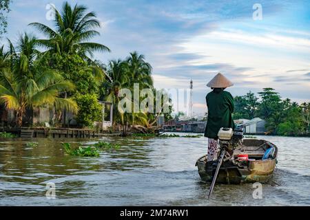 Can Tho, Vietnam - 4. Januar 2023: Eine Frau, die auf einem Boot im Mekong-Delta in Can Tho, Vietnam segelt. Stockfoto