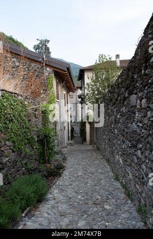 Lecco, Italien - 29. April 2022: Sehr enge Straße zwischen Gebäuden im italienischen Gebirge. Stockfoto