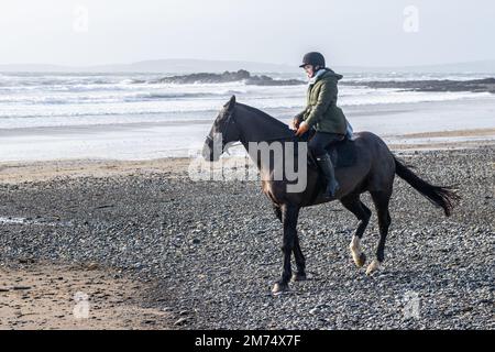 Garrylucas Beach, West Cork, Irland. 7. Januar 2023. Met Eireann hat eine gelbe Wetterwarnung für fünf Bezirke ausgegeben. Die gelbe Windwarnung gilt für die Grafschaften Kerry, Clare, Galway, Mayo und Donegal und gilt bis morgen früh um 08,00 Uhr (so 8. Uhr). Alison Chambers aus Garretstown nahm ihr Pferd 'TJ' für eine Fahrt am Strand mit. Kredit: AG News/Alamy Live News Stockfoto