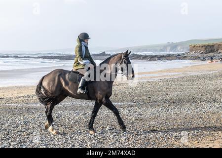 Garrylucas Beach, West Cork, Irland. 7. Januar 2023. Met Eireann hat eine gelbe Wetterwarnung für fünf Bezirke ausgegeben. Die gelbe Windwarnung gilt für die Grafschaften Kerry, Clare, Galway, Mayo und Donegal und gilt bis morgen früh um 08,00 Uhr (so 8. Uhr). Alison Chambers aus Garretstown nahm ihr Pferd 'TJ' für eine Fahrt am Strand mit. Kredit: AG News/Alamy Live News Stockfoto