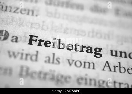 Eine Kurzfassung des deutschen Wortes Freibetrag in fetter Schrift, umgeben von verschwommenen Wörtern Stockfoto