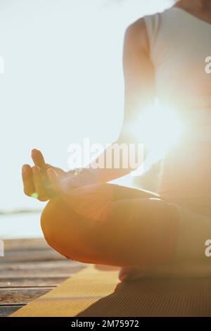 Nahaufnahme einer Jogi-Frau, die in einer Lotusposition sitzt und meditiert. Stockfoto