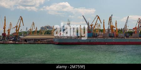 Odesa, Ukraine. 22. Juli 2021. Panoramablick auf den Schwarzmeerhafen im Sommer. Krane entladen ein Handelsschiff. Stockfoto