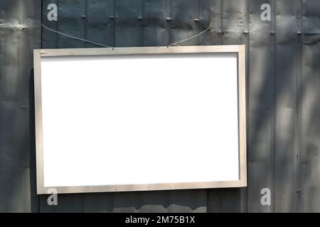 Rahmenmodell. Einfacher Holzrahmen auf Metallzaun im Außenbereich Stockfoto