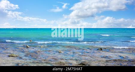 Karibische Meereslandschaft mit Felsen im flachen Wasser an einem sonnigen Tag. Stockfoto