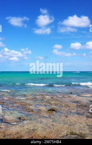 Karibische Meereslandschaft mit Felsen im flachen Wasser an einem sonnigen Tag. Stockfoto