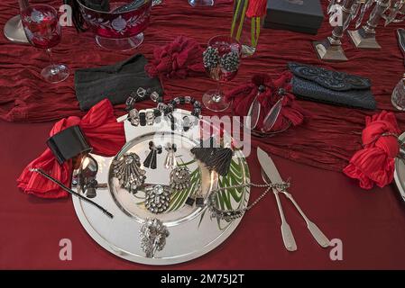 Strassschmuck und Accessoires, dekoriert auf einer Silberplatte und rotem Stoff, Bayern, Deutschland Stockfoto