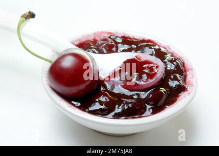 Kirschmarmelade in kleinen Schüsseln und schwarze Wildkirsche (Prunus avium) Stockfoto