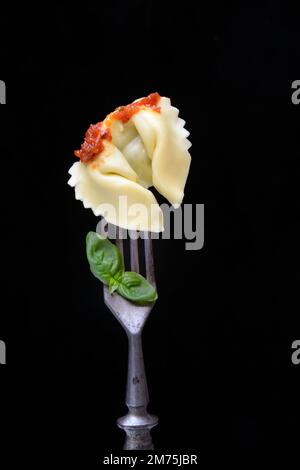 Tortelloni mit Tomatensoße auf einer Gabel, Pasta, Pasta Stockfoto
