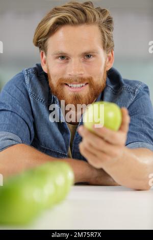 Grüner Apfel in einer männerpalme Stockfoto