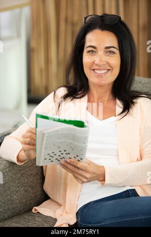 Reife Frau genießt ein Puzzlebuch Stockfoto