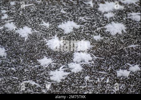 Abstraktes Frostmuster auf der Straße. Nahaufnahme strukturierter Schneeflocke aus mattiertem Kristall. Stockfoto