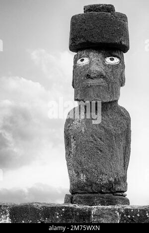 Nahaufnahme eines wiederaufgebauten Moai in Ahu Tahai mit restauriertem Pukao und Nachbildung von Korallenaugen, Osterinsel, Chile in Schwarz und Weiß Stockfoto