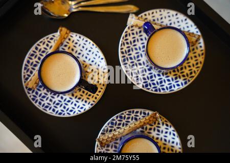 Türkischer oder französischer Kaffee mit Schaumgerichten und traditionellem Servierset. Blau-weißes Keramikkaffee-Set Stockfoto