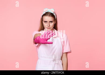 Hübsche Frau in Handschuhen und sauberer Schürze Stockfoto