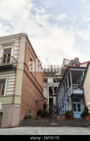 Tiflis, Georgia - 15.04.2021: Eine enge alte Straße in Tiflis mit einer Treppe zwischen den Häusern Stockfoto