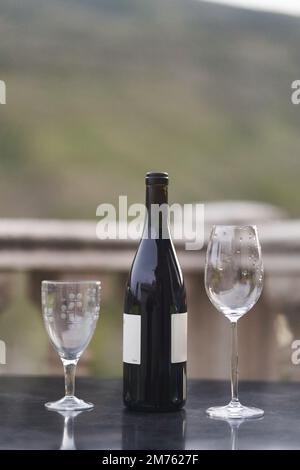 Eine Flasche Wein und zwei Gläser auf dem Tisch auf dem Balkon des Restaurants Stockfoto