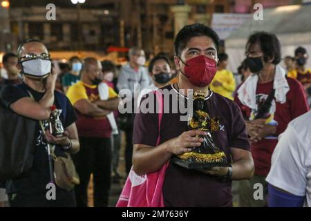 Pasay City, Metro Manila, Philippinen. 8. Januar 2023. Ein philippinischer katholischer Anhänger hält eine Miniaturstatue des Schwarzen Nazarens, während er am Walk of Faith im Rahmen der jährlichen Feier des Fests des Schwarzen Nazarens am 8. Januar 2023 in Manila teilnimmt. (Kreditbild: © Earvin Perias/ZUMA Press Wire) Stockfoto