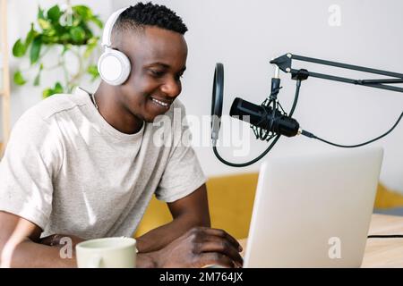 Junger kreativer männlicher afrikanischer Podcaster, der Radio-Podcast aus dem Heimstudio macht Stockfoto